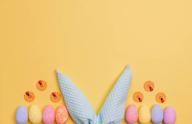 istock Colorful Easter eggs and rabbit ears made of napkins. Easter background with free space. 1472264712