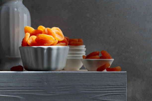 Dried apricots on a white wooden table.