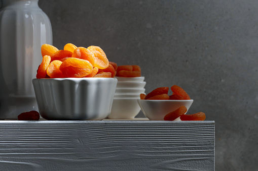 Dried apricots on a white wooden table. Copy space.