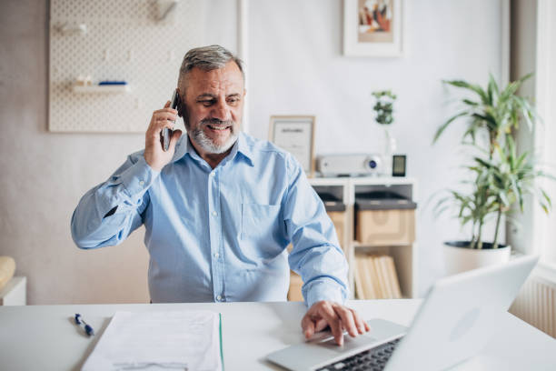 istock Higher manager uses mobile phone, looking at the laptop 1472264994