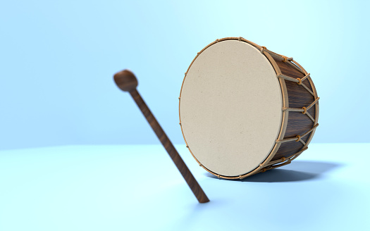 Traditional Ramadan drum and drum stick on blue background. Ramadan concept.