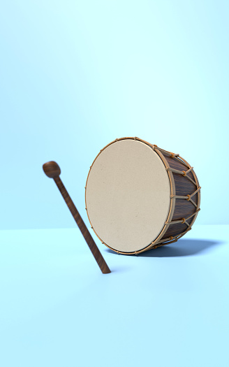 Traditional Ramadan drum and drum stick on blue background. Ramadan concept.