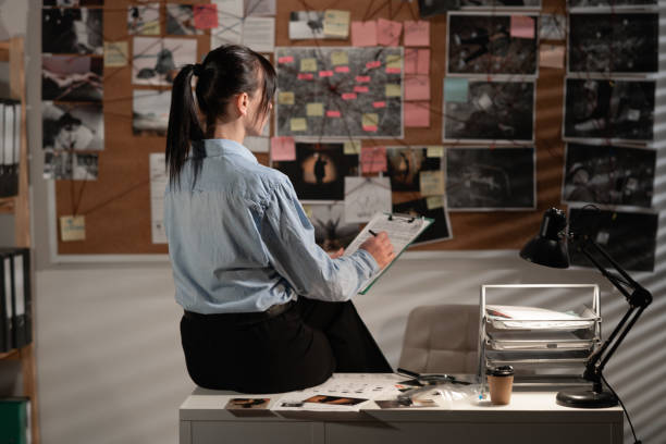 istock Detective carefully looking at the evidence board, back view. 1472274528
