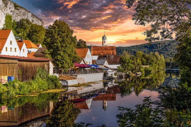 Idyllic sunset view with reflections of Markt Essing with the ruin of Randeck castle over the river Altmuehl in Bavaria, Germany