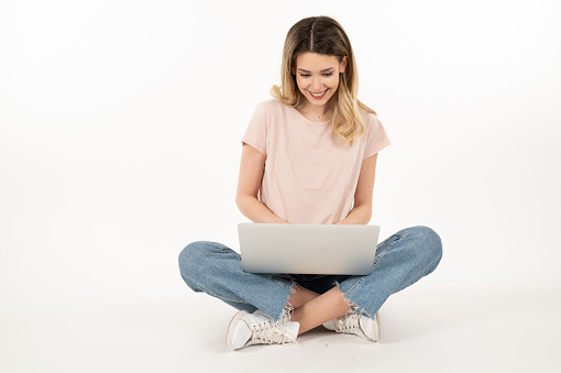 Happy young woman sitting and using laptop\nHappy winning face