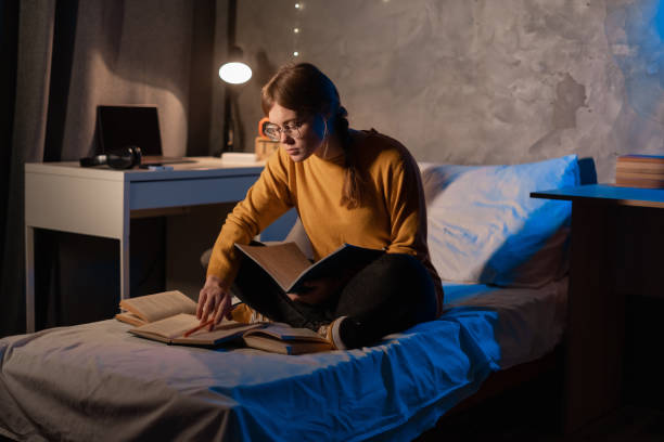 istock Smart female student prepare for exam in dormitory room at night. 1472280447
