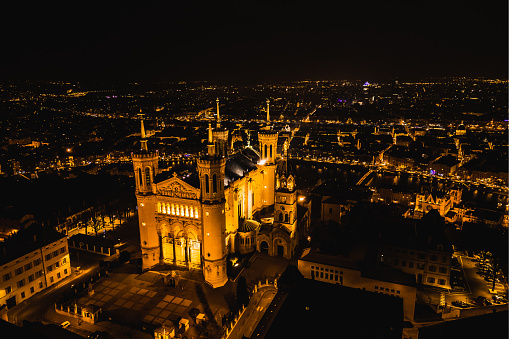 Panoramic aerial shot at night time of illuminated Basilica Notre Dame de Fourviere - Lyon