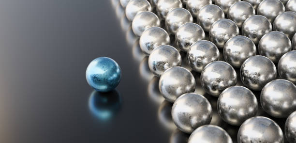 Leadership concept, blue leader ball, standing out from the crowd of silver balls, on black background stock photo