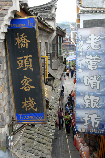 Fenghuang, Hunan Province, China: Signs in Fenghuang ancient town and view to the street below. The town is home to Miao and Tujia minority peoples.