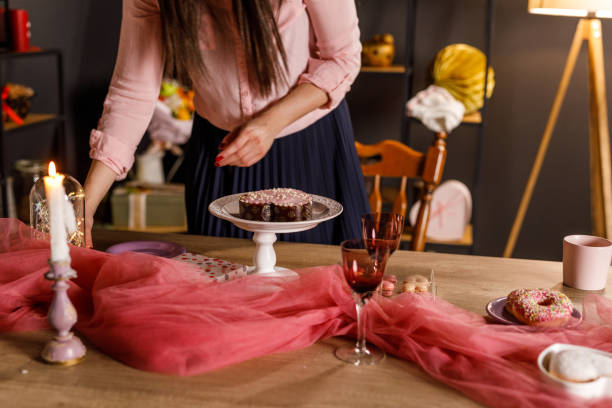 istock Young woman serving a cute heart shaped cake on a table 1472287759