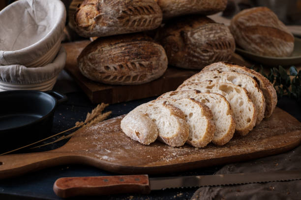 istock Artisan Batard Sourdough healthy Bread with leaf scoring. Open crumb high hydration Sourdough bread set on white table. 1472288846