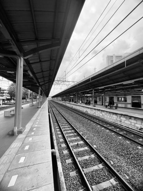Train platform with people waiting for train in black and white mode