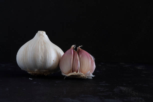 istock Garlic and garlic cloves isolated on a black background 1472289996
