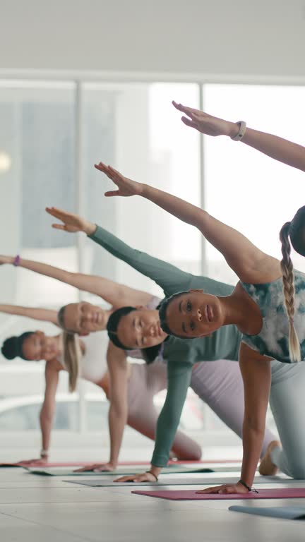 Stretching, posing and women in a yoga class for fitness, training and health. Start, floor and friends doing pilates for muscle flexibility, zen sport and exercise at the gym for a team workout