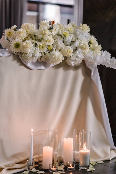 istock Table newlyweds covered a tablecloth in banquet area on wedding party. Table setting. Celebration concept. Wedding reception. Festive arch decorated composition flowers and candles in hall restaurant. 1472290810