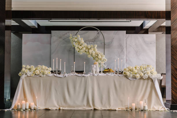 istock Wedding reception. Festive arch decorated composition flowers and candles in hall restaurant. Table newlyweds covered a tablecloth in banquet area on wedding party. Table setting. Celebration concept. 1472290812