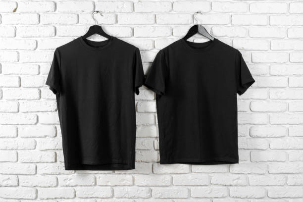 istock Black t-shirt hanging on a hanger against brick wall 1472291578