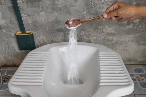 istock Man using baking soda to clean toilet bowl 1472291949