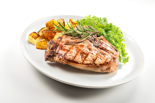 Dish with Grilled t-bone chop of pork with salad and potatoes