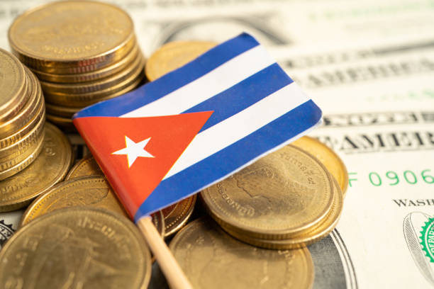 istock Stack of coins with Cuba flag and US dollar banknotes. 1472295189