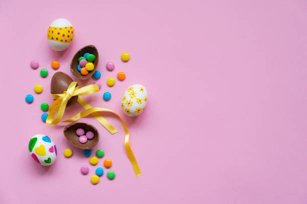 Easter chocolate eggs and candies on a pink background