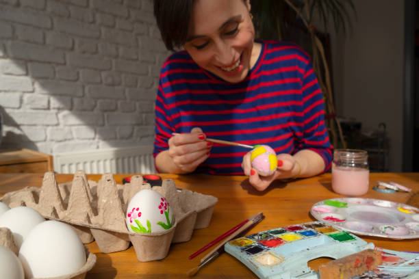 istock Woman painting Easter Egg and preparing for Easter holiday celebration 1472298011