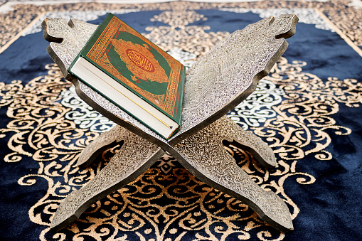 muslim book with Arabic calligraphy Quran translation :  holy book of Muslims  on wooden stand