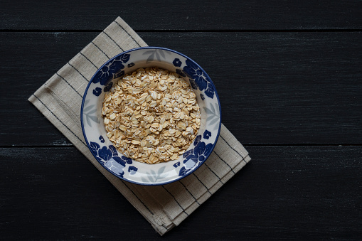 Oat flakes in a bowl on the wooden table