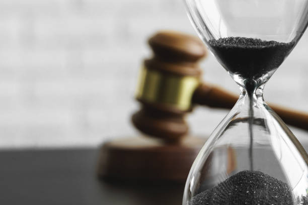 Court concept. Hourglass and judge gavel on table stock photo
