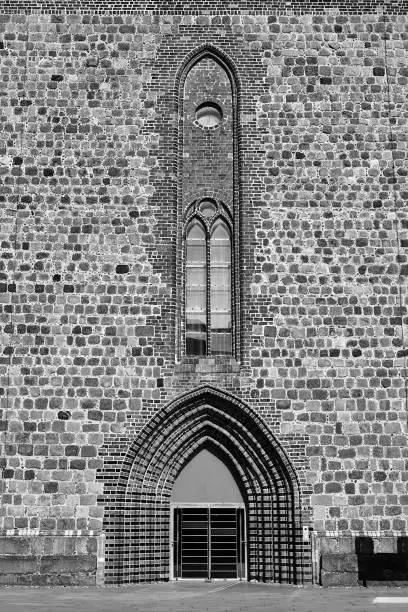 Portal and entrance to the medieval St.-Marien-Kirche Evangelical Church in the city of Neubrandenburg, Germany, monochrome