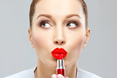 Red  lips.young woman using lipstick