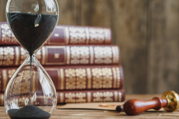 istock Vintage hourglass against a stack of old books 1472305542