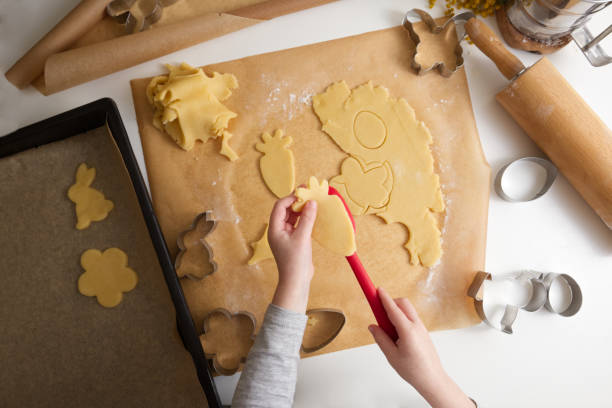 istock Children's hands cut out a shape for Easter cookies on rolled out dough in a spring decor 1472306884