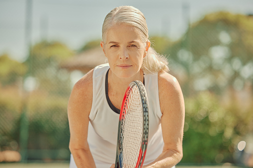 Tennis, woman and face, sport and fitness on outdoor court, focus and portrait with athlete and active lifestyle. Health, wellness and sports training, mature female and racket, ready to play game