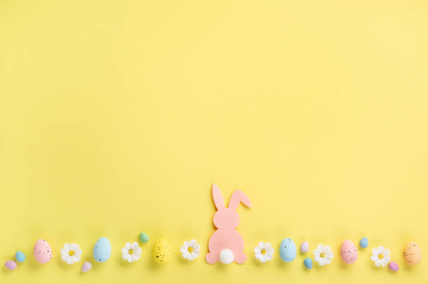 istock Easter Eggs with Sweets and Spring Flowers on Yellow Background 1472307424