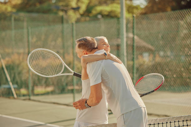 tennisplatz, paar und umarmung für fitness im freien bei sportspiel, spiel oder wettbewerb. reifer mann und frau glücklich über sieg für training, cardio-training oder ballsportleistung oder training - tennis court love victory stock-fotos und bilder