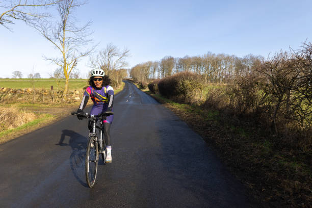 Woman riding her bike in a rural area in the countryside, staying active in the North East of England.