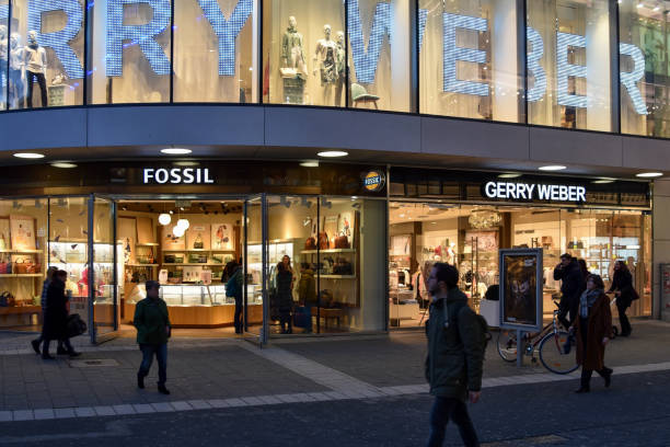 The Gerry Weber and Fossil stores on Schadowstrasse in Düsseldorf at dusk. Duesseldorf, Germany, February 12, 2020 -The Gerry Weber and Fossil stores on Schadowstrasse in Duesseldorf at dusk. halle north rhine westphalia stock pictures, royalty-free photos & images