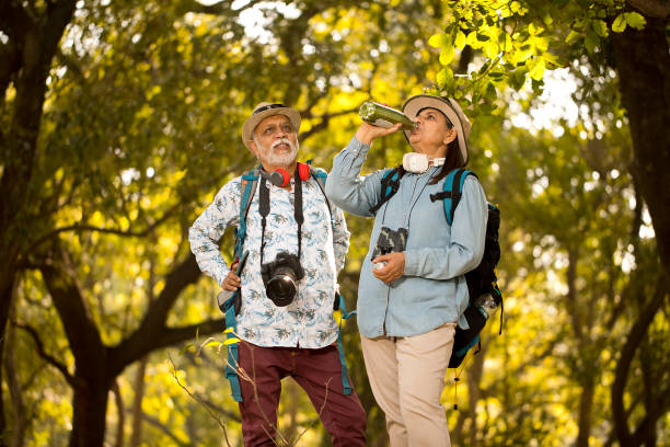 istock Joyful couple admiring nature at forest during vacation post retirement 1472312989