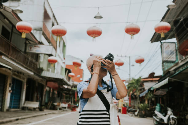 Happy senior adult as a photographer spending her retirement life with shooting her goal travel plan.
