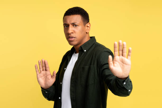 istock Confident young man with serious face showing stop gesture with his palm 1472315800