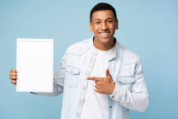 istock Positive man pointing finger at frame paying your attention at empty space 1472317439