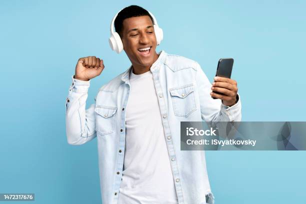 Multiracial Man Wearing Headphones Using Smartphone Listening Music And Dancing Stock Photo - Download Image Now