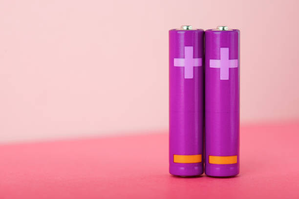 Purple AA type batteries on a pink table