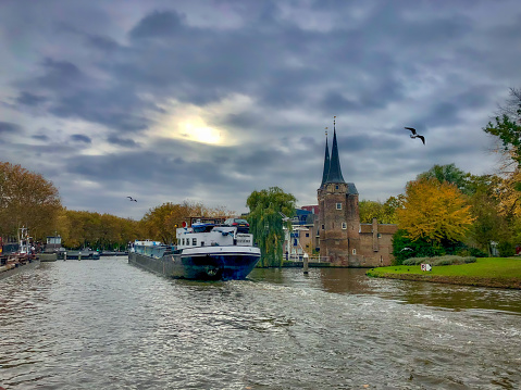 Delft, the Netherlands - November, 2018: Moody skies and a boat in the Schie canal.