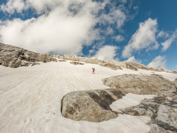 mountain climber moving up on snowy route - conquering adversity wilderness area aspirations achievement imagens e fotografias de stock