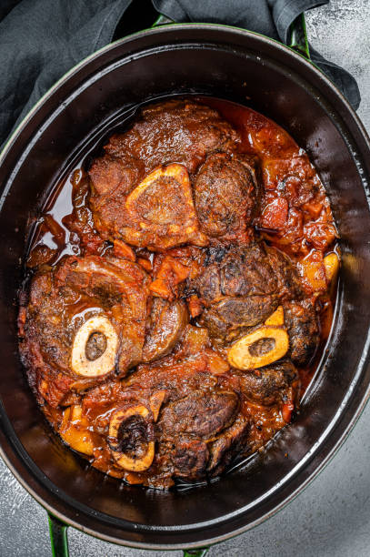 Osso buco cross cut veal shank braised with tomatoes and spices, beef meat Ossobuco. White background. Top view Osso buco cross cut veal shank braised with tomatoes and spices, beef meat Ossobuco. White background. Top view. ossobuco stock pictures, royalty-free photos & images