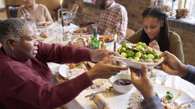 Family members passing food during elegant Christmas lunch