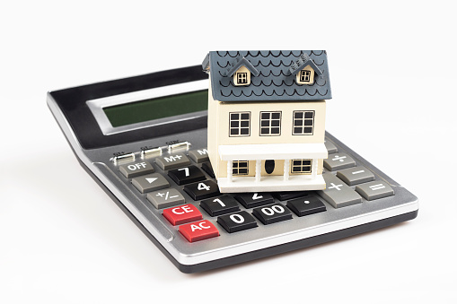 House model and calculator on white background