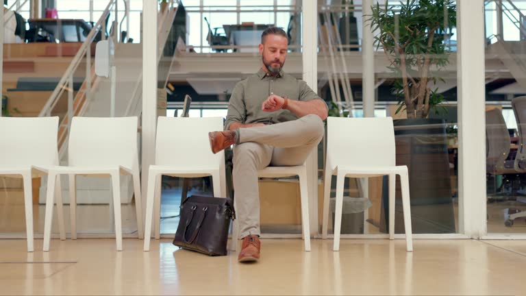 Business, man and nervous for job interview, watch and guy in modern office, impatient and stress. Male employee, consultant or waiting for appointment, deadline or worker with anxiety or frustration